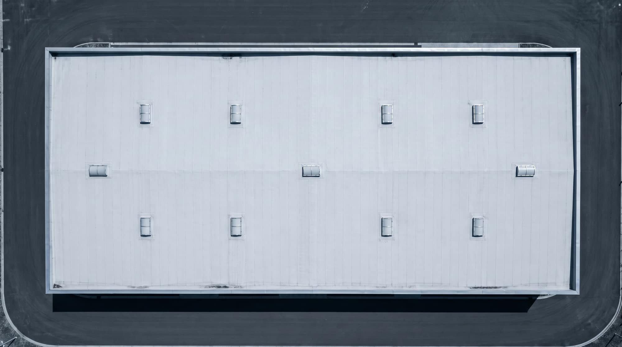 Rechtstreeks luchtbeeld van een rechthoekig, leeg fabrieksdak, klaar voor analyse.